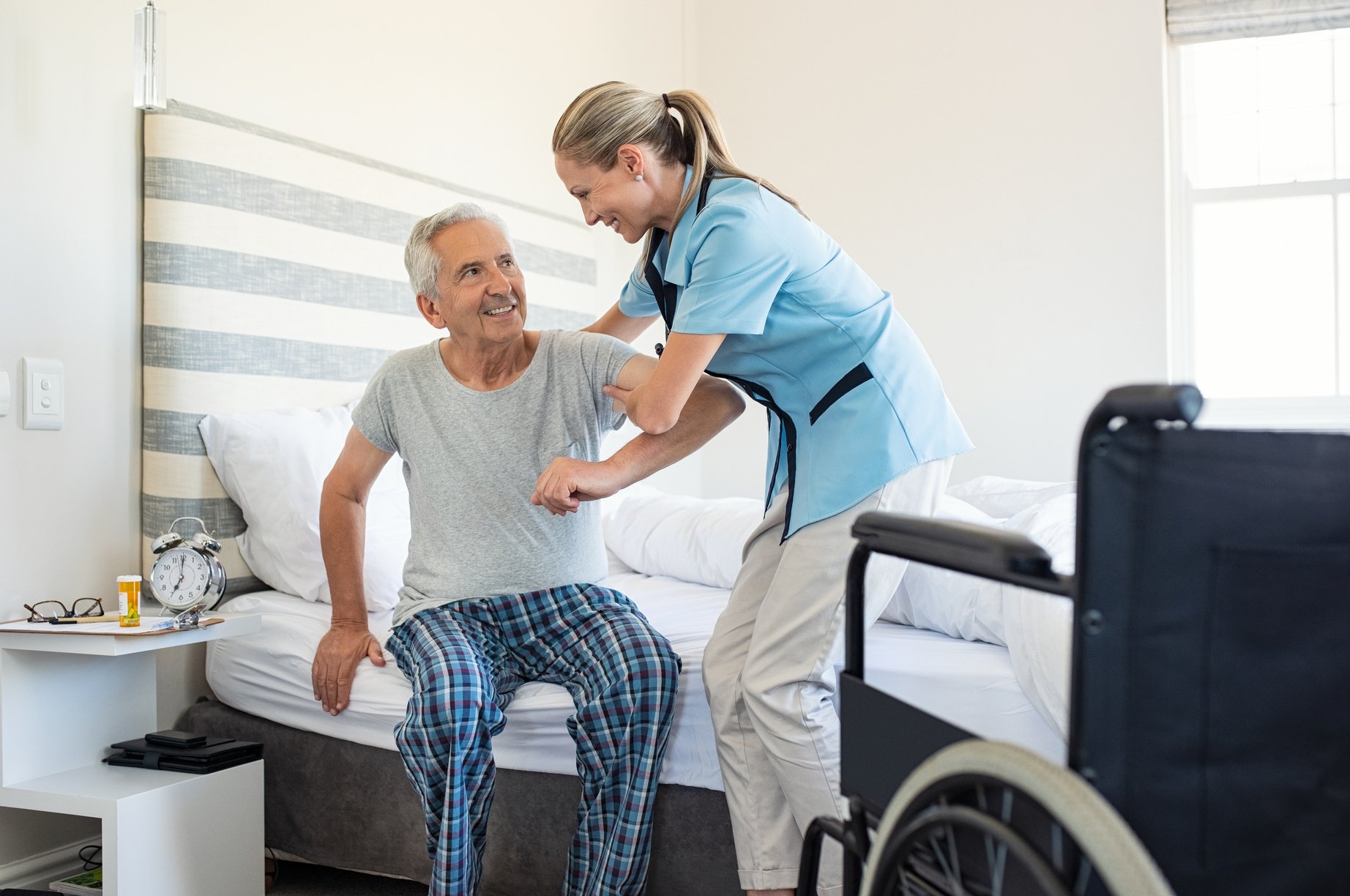 Nurse helping old patient get up